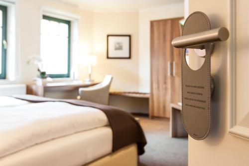 a hotel room with a bed and a desk at Hotel Mecklenburger Hof Gnoien in Gnoien