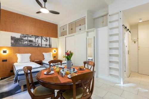 - une salle à manger avec une table, des chaises et un lit dans l'établissement La plume de Paul, à Nice