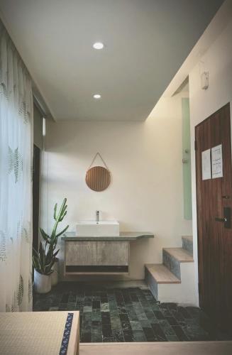 a bathroom with a sink and a counter with stairs at 定春行旅 Haru Guesthouse in Tainan
