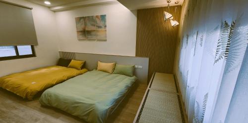 a bedroom with two beds and a window at 定春行旅 Haru Guesthouse in Tainan