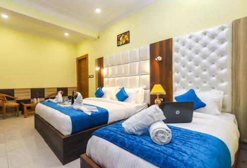 ein Hotelzimmer mit 2 Betten und einem Laptop darauf in der Unterkunft Hotel yellow nest inn in Dharamshala