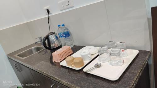 a kitchen counter with a sink and glasses on it at Coorg ASHOK PALACE in Madikeri