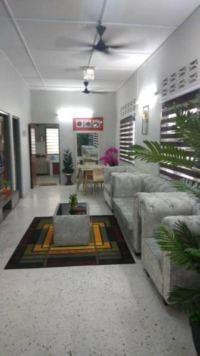 uma sala de estar com um sofá e uma mesa em IPOH Homestay em Ipoh