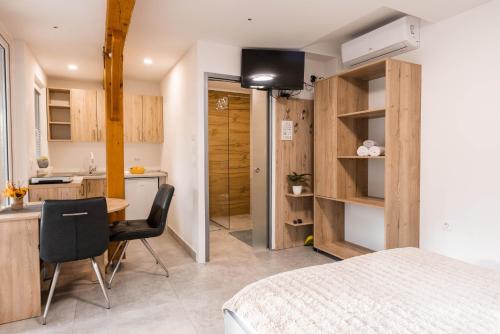 Adlešiči的住宿－Apartmaji Natura KOLPA，一间带一张床和一张书桌的卧室和一间厨房