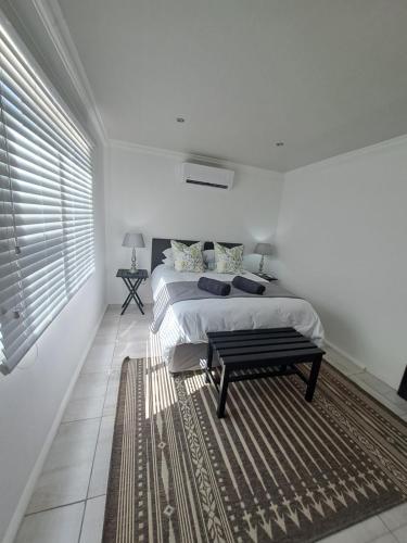 una camera bianca con un letto e un tappeto di GRACE'S PLACE a Beaufort West