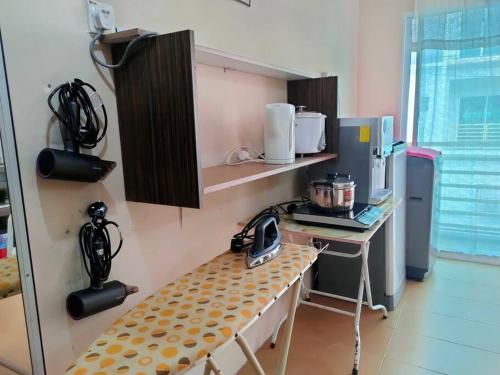 a kitchen with a counter and a table in a room at 1 MINUTES TO TOWER SENTRAL INTAN HOMESTAY 6 ROOMS in Teluk Intan