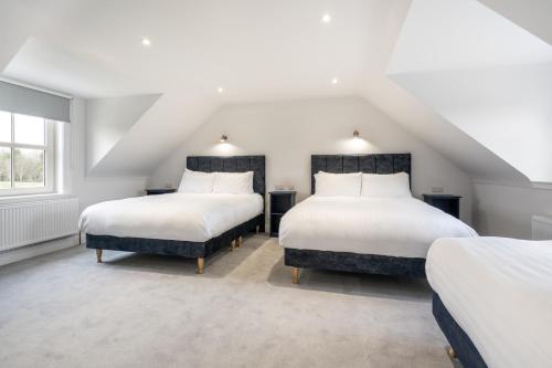 two beds in a attic bedroom with white walls at THE WHITE HOUSE AT MULLANS BAY in Enniskillen