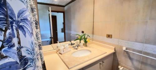 a bathroom with a sink and a mirror at Casa en Zapallar con hermosa vista y jardín. in Zapallar