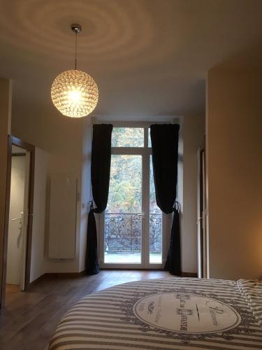 une chambre avec un grand lit avec une grande fenêtre dans l'établissement Chambre paisible avec vue sur la montagne, à Conliège