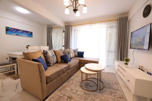 a living room with a couch and a table at Lux Suites Sandalwood Furnished Apartments in Nairobi