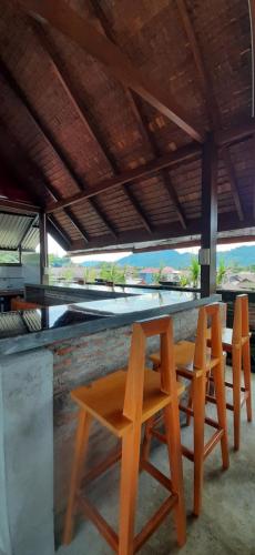a group of chairs and a table with a view of the ocean at GUEST Toraja Homestay in Rantepao