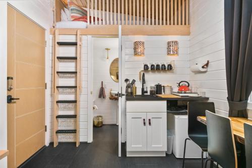 a tiny house with a kitchen and a loft bed at Tiny Digs - Hotel of Tiny Houses in Portland