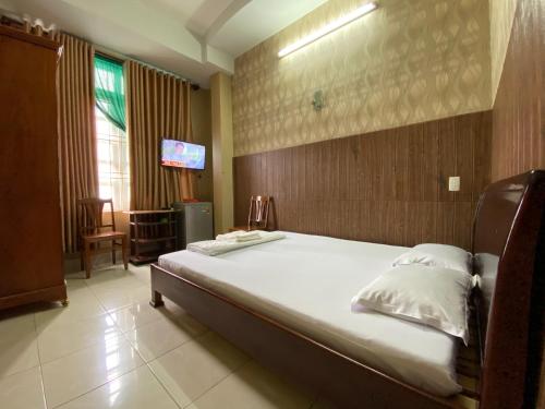 um quarto com uma cama grande e uma televisão em Thu Đô Motel em Vung Tau