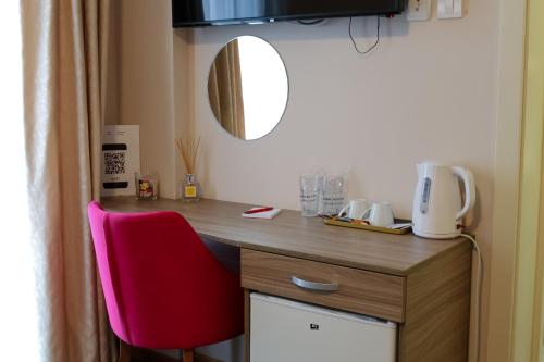 a desk with a red chair in a room at Smeštaj Tank, Pančevo in Salaši