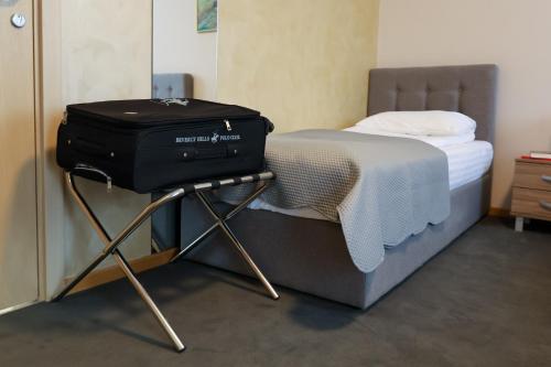 a suitcase sitting on a stand next to a bed at Smeštaj Tank, Pančevo in Salaši