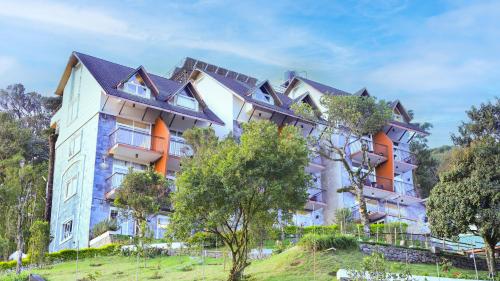 a large building on a hill with trees at Shola Crown Resort - Munnar in Chinnakanal