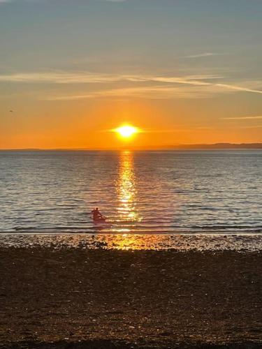 a person in the water at the beach at sunset at Beachfront Treasure in Musselburgh