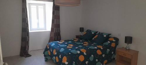 une chambre avec un lit avec une couette et une fenêtre dans l'établissement GITE DE LA COMBE BASSE, à Le Masnau-Massuguiès