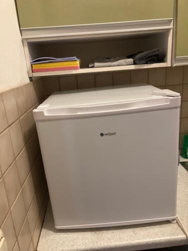 a white refrigerator in a kitchen with a shelf at Einfaches grosse geräumiges Wohnung für Monteuren in Dortmund