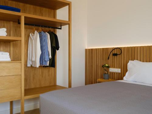 a bedroom with a bed and a wooden closet at Sea La Vie in Adelianos Kampos