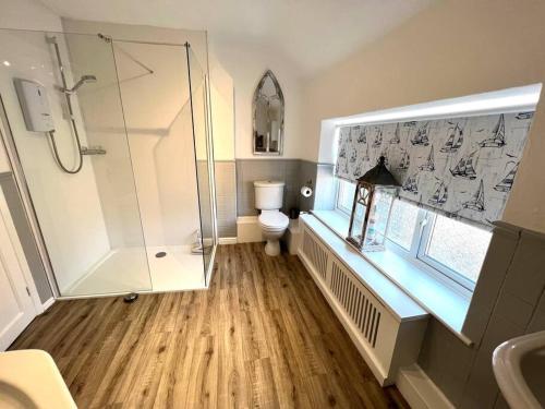 a bathroom with a shower and a toilet and a sink at Anchor Cottage - beautiful two bedroom cottage in the heart of Holt in Holt