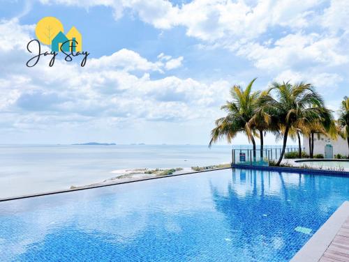 a swimming pool with a view of the ocean at SilverScape Residence I Luxury 2-4 BR I 6-11 pax I Bathtub I Seaview I Infinity Pool I Jonker St I City Centre by Jay Stay Management in Melaka