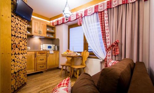 a living room with a couch and a kitchen at Apartamenty u Stopków in Biały Dunajec