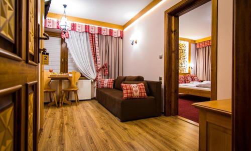 a living room with a couch and a bedroom at Apartamenty u Stopków in Biały Dunajec