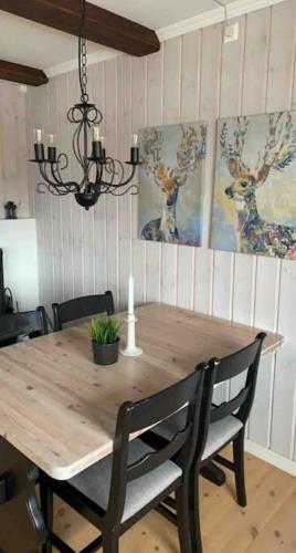 a wooden dining room table with chairs and a chandelier at Gaustablikk - ski in & out apartment - Mountain View in Gaustablikk