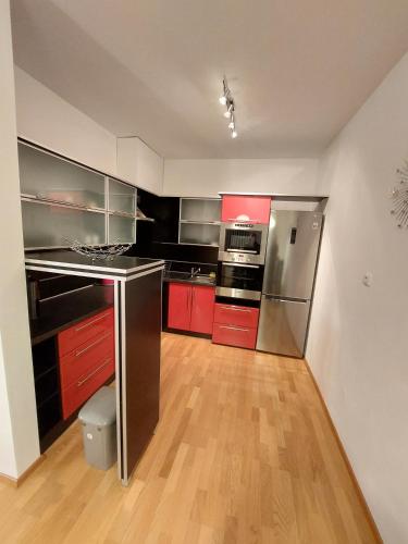 a kitchen with red cabinets and stainless steel appliances at Appartement LARA SPA Čeladná in Kunčice pod Ondřejníkem