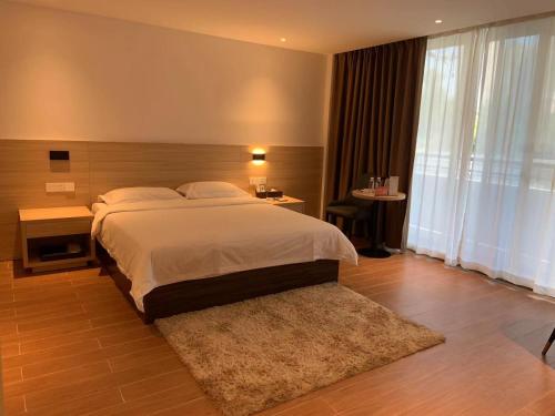 a bedroom with a large bed and a large window at Guangzhou Fangyuan Hotel in Guangzhou