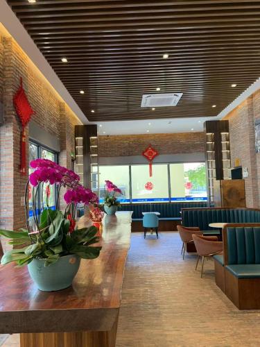 a lobby with purple flowers on a wooden table at Guangzhou Fangyuan Hotel - Free Shuttle Bus to Canton Fair Complex during 14th Oct to 3rd Nov in Guangzhou