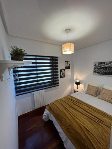 Un dormitorio con una cama grande y una ventana en Piso Confort y Detalles Ourense, en Ourense