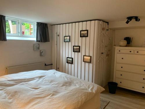 a bedroom with a white bed and a dresser at Cosy Private room close to Copenhagen centre in Copenhagen