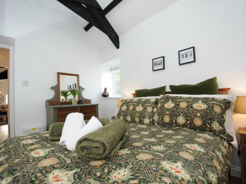 a bedroom with a king sized bed with a patterned blanket at Pheasant Barn in Liskeard