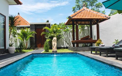 a swimming pool in a backyard with a gazebo at Kubu Garden Suites & Villas Nusa Dua in Nusa Dua