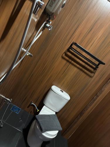 a toilet in a bathroom with a wooden wall at Tatami D'Tepi Laut - PANGKOR ISLAND in Pangkor