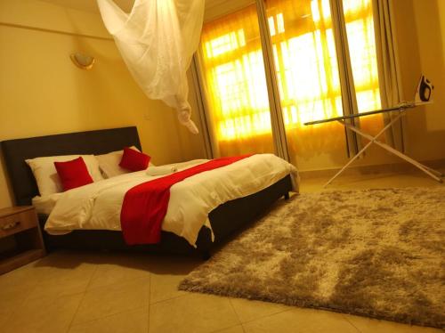 a bedroom with a bed with red pillows and a rug at Musundi Luxury Homes in Kakamega