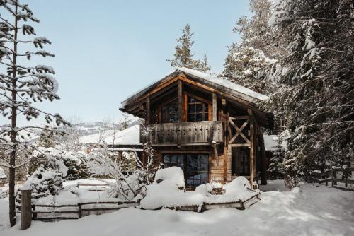 a log cabin is covered in snow at Hotel Chalet Corso in San Vigilio Di Marebbe