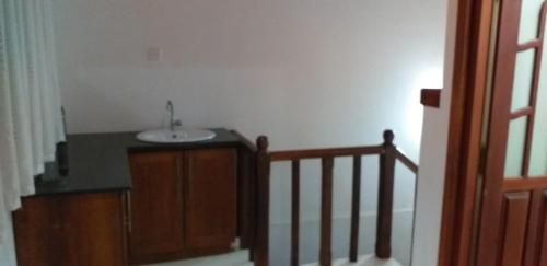 a bathroom with a sink and a staircase at Sujee Villa White House in Beruwala