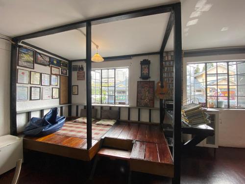 een kamer met een bank, een tafel en een aantal ramen bij Hikers Sleep Port Guesthouse in Cameron Highlands