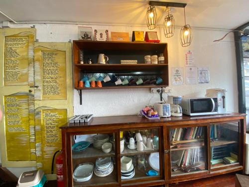 a counter in a room with dishes on shelves at Hikers Sleep Port Guesthouse in Cameron Highlands