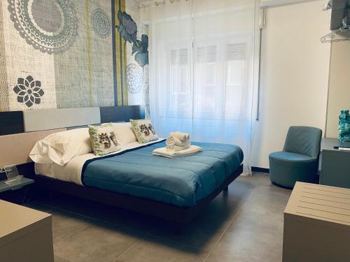 a bedroom with a bed and a blue chair at I Cinque Mori DEVA in Siracusa