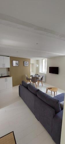 un salon avec un canapé bleu et une table dans l'établissement APPARTEMENT LE PHARE AU PIED DU PORT, à Saint-Valery-en-Caux