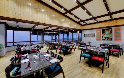 a restaurant with tables and chairs in a room at Sumitel Vista 800m from Mall Road in Darjeeling