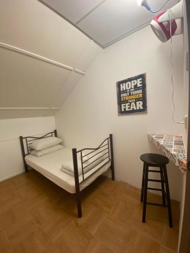 a bed in a room with a sign on the wall at Hikers Sleep Port Guesthouse in Cameron Highlands