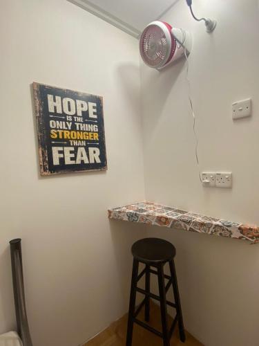 a fan and a stool in a room with a counter at Hikers Sleep Port Guesthouse in Cameron Highlands