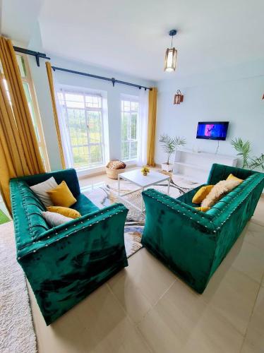 sala de estar con 2 sofás verdes en Cossy homes kericho grey point, en Kericho