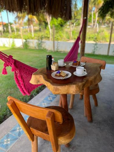 een houten tafel met een bord eten erop bij Pousada Corália in São Miguel dos Milagres