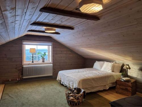 1 dormitorio en el ático con cama y ventana en Backens Fjällboende, en Tännäs